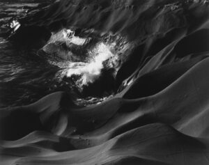 A black and white photo of water swirling in the ocean.