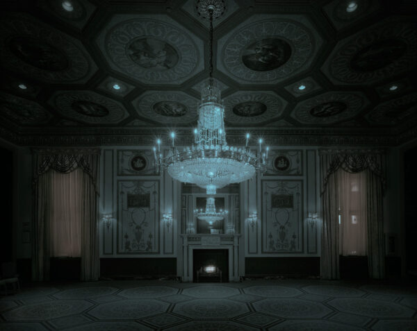 A chandelier in the middle of an empty room.