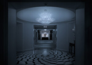 A hallway with a large white floor and a light on the ceiling.