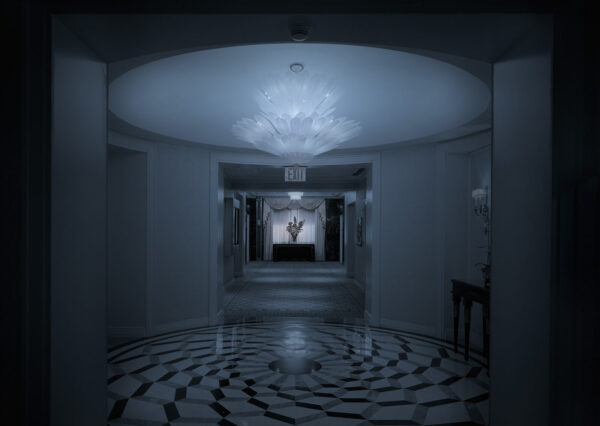 A hallway with a large white floor and a light on the ceiling.