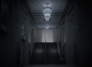 A dark hallway with lights and stairs leading to the top floor.