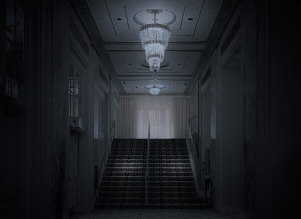 A dark hallway with lights and stairs leading to the top floor.