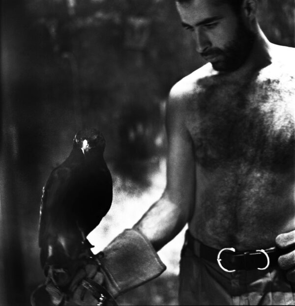 A man holding a bird in his hand.