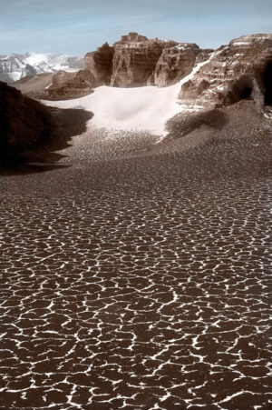 A beach with sand and rocks in the water.