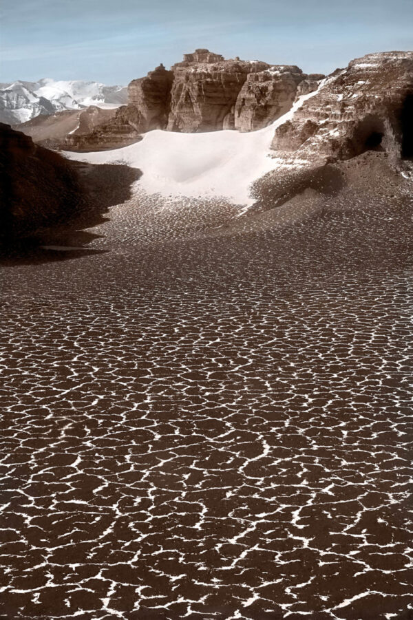 A beach with sand and rocks in the water.