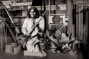 A man holding an arrow and sitting on a chair.