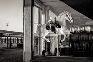 A horse statue sitting in front of a window.