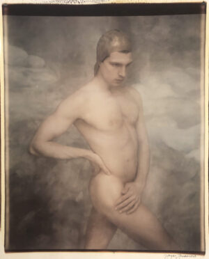 A man standing in the clouds with his hands on his hips.
