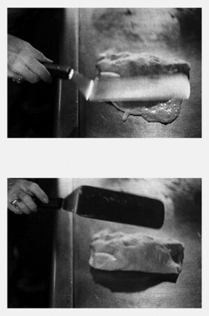 A person holding a knife and cutting meat.