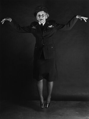 A man in military clothing standing with his arms outstretched.