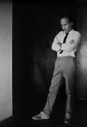 A man standing in front of a wall with his arms crossed.