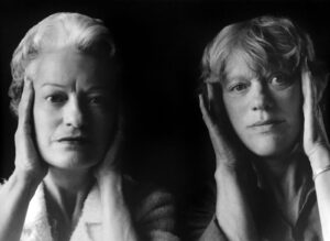 Two women are posing for a picture in front of each other.