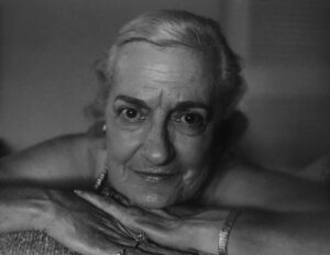 A woman with white hair is leaning on her arms.