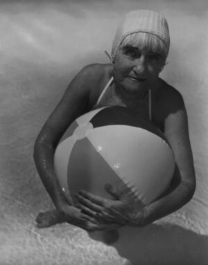 A woman in a bathing suit holding a beach ball.