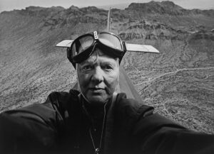 A man in goggles and an airplane helmet.