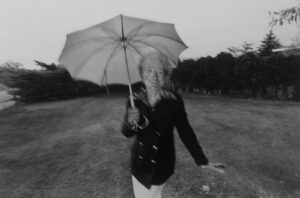 A woman holding an umbrella in the middle of nowhere.