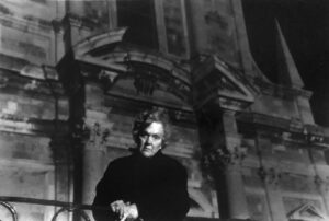 A man standing in front of an old building.