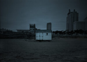 A white building sitting in the middle of a field.