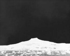 A black and white photo of a mountain with snow on it.