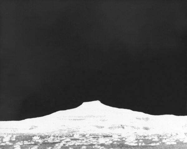 A black and white photo of a mountain with snow on it.