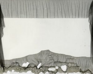 A white wall with some gray fabric on it