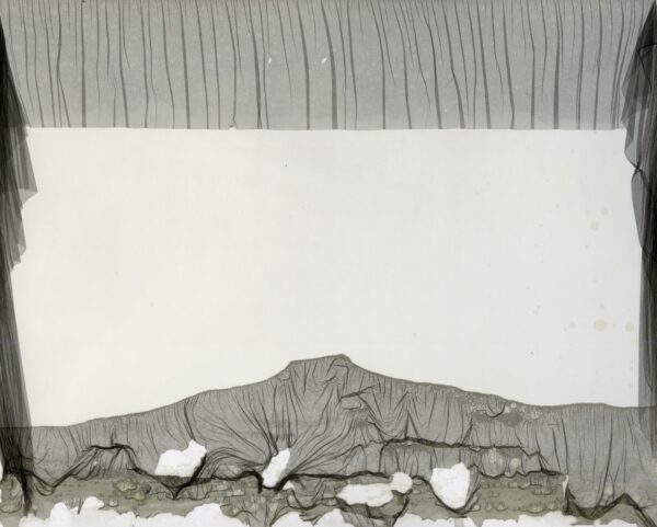A white wall with some gray fabric on it