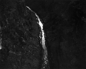 A black and white photo of a waterfall