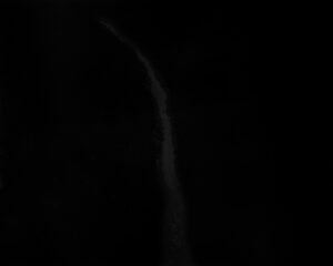 A black sky with a white cloud in the middle