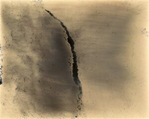 A crack in the ground is shown on top of a wall.