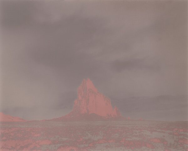 A red mountain in the distance with dark clouds.
