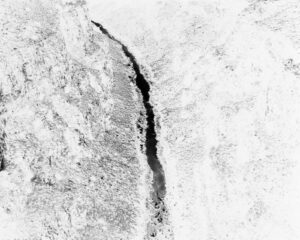 A black and white image of a crack in the ice.