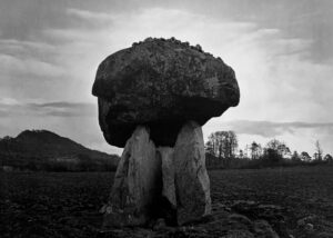A large rock sitting in the middle of a field.