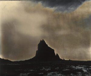 A mountain with dark clouds in the background.
