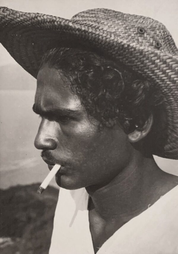 A man in a straw hat smoking a cigarette.