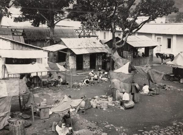 A black and white photo of people in the street.
