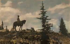 A man on horseback in front of a tree.