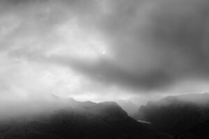 A black and white photo of some mountains in the distance