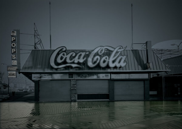 A coca cola sign sitting in the middle of water.