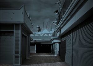 A dark street with many buildings and some lights