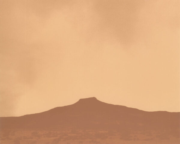 A brown sky with some clouds and mountains