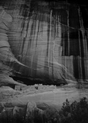 A black and white photo of the side of a cliff.