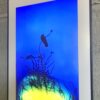 A painting of flowers and plants on a blue background.
