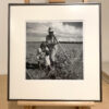 A black and white photo of two people in the field