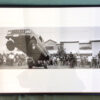 A large picture of people and vehicles in front of a building.
