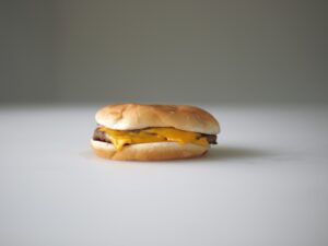 A cheeseburger sitting on top of a bun.