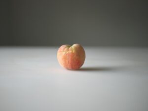 A peach sitting on top of a table.