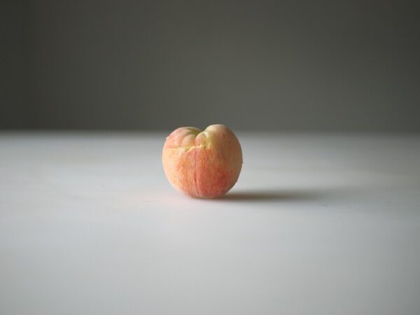 A peach sitting on top of a table.