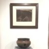 A picture of a pot and a painting on the wall.