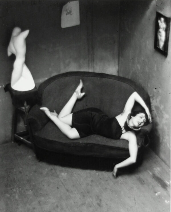 A woman laying on the couch with her legs crossed.