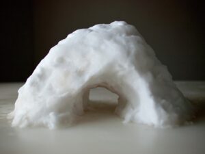 A small igloo made of snow on top of a table.